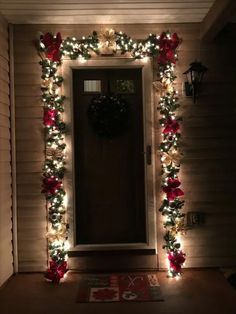 the front door is decorated with christmas lights and poinsettia garlands for an elegant touch