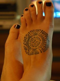 a woman's foot with a tattoo on it and a television in the background