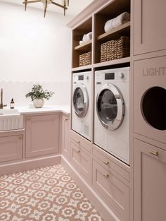 a washer and dryer sitting in a room next to a counter with baskets on it