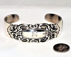 "This is a vintage Towle sterling silver cuff bracelet in the Grand Duchess pattern with a monogram E. The bracelet has a 7.5\" circumference or 2.5\" in diameter with a 1.5\" gap in the back, weighs 46.1 grams on my scale and is in excellent condition. My wrist is 7\" and this fits nicely with room to spare. The bracelet will be gently cleaned with a jewelers cloth before before being sent, gift box included. Vintage dime not included." Antique Engraved Cuff Bracelet For Anniversary, Antique Stamped Cuff Bracelet For Formal Occasions, Victorian Engraved Cuff Bracelet For Anniversary, Engraved Antique Cuff Bracelet For Anniversary, Vintage Sterling Silver Bracelet For Anniversary, Silver Stamped Cuff Bracelet For Wedding, Vintage Stamped Cuff Bracelet For Wedding, Vintage Silver Cuff Bracelet Hallmarked, Vintage Silver Hallmarked Cuff Bracelet