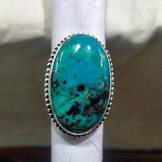 Natural Chrysocolla // Chrysocolla Silver Ring // Statement Ring // 925 Sterling Silver // Silver Ring // Shape Oval // Size 35x22 MM Stone Size = 35x22 MM Stone Shape = Oval Weight in Grams = 17.65 gm (approx) About Chrysocolla :- Due to being somewhat more common than turquoise, its wide availability, and vivid, beautiful blue and blue-green colors, chrysocolla has been popular for use as a gemstone for carvings and ornamental use since antiquity. It is often used in silversmithing and goldsmithing in place of turquoise and is relatively easy to work and shape. Chrysocolla exhibits a wide range of Mohs hardness ranging from 2 through 7, which is dependent on the amount of silica incorporated into the stone when it is forming. Generally, dark navy blue chrysocolla is too soft to be used i Copper Mineral, Friendship Symbols, Cyan Blue, Ring Shapes, Plexus Products, Statement Ring, Rings Statement, Beautiful Blue, Green Colors