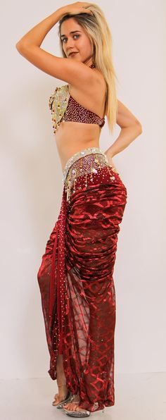 This show-stopping two-piece set showcases beautiful embellishments such as rhinestones, beads, and embroidery in a majestic shade of Burgundy. This two-piece costume features a dina halter bra, and built-in shorts with embellished dazzling crystals. Length is from the top of the skirt. Fitted Belly Dance Sets For Party, Fitted Red Embellished Sets, Elegant Embellished Sets For Celebration, Embellished Red Sets For Party, Embellished Red Party Sets, Fitted Burgundy Party Sets, Glamorous Red Sequined Sets, Fitted Bollywood Embellished Sets, Elegant Fitted Sets With Stone Work