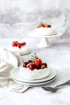 two plates with desserts on them and one plate has strawberries in it, the other is topped with whipped cream