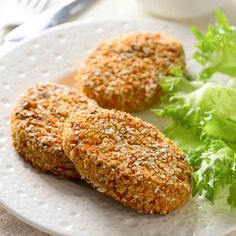 two fried meat patties on a plate with lettuce