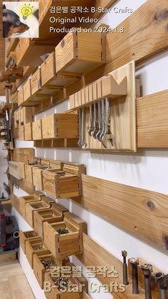 there are many wooden drawers on the wall in this shop, and one is holding tools