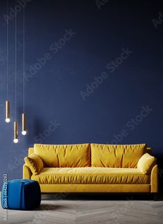 a living room with blue walls and yellow couch in the center, two pendant lights hanging from the ceiling