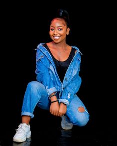 a woman in jeans and sneakers posing for a photo