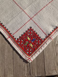 a red and white table cloth sitting on top of a wooden surface