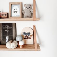 two wooden shelves with books and toys on them, one shelf has a teddy bear