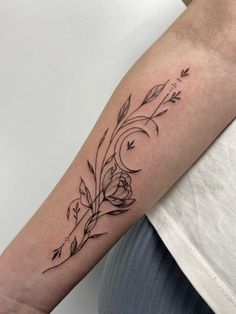 a black and white photo of a woman's arm with flowers on it