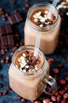 two cups filled with chocolate and nuts on top of a table