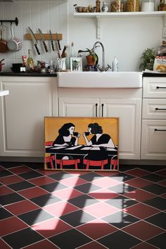 a painting sitting on top of a kitchen floor next to a sink and countertop