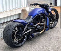 a blue motorcycle parked in front of a building