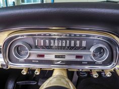 an old car dashboard with the radio on it's dash board and steering wheel