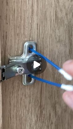 someone is opening the door with their thumbnails and pulling on blue string to open it