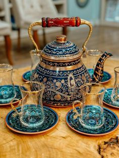 a tea pot and four glasses on a table