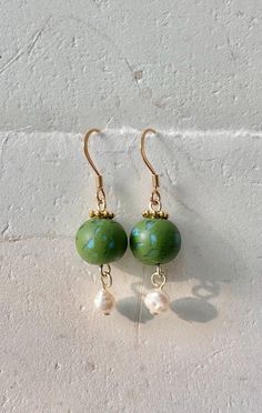 Handmade olive green and blue polymer clay bead dangle earrings with dyed cultured pearls and an 18k gold plated stainless steel fishhook style earring. Patterns on clay beads vary from piece to piece. 14k Gold-filled Beaded Drop Earrings, Green 14k Gold-filled Dangle Earrings, Green 14k Gold Filled Dangle Earrings, Adjustable Round Beads Jade Earrings, Adjustable Jade Earrings With Ear Wire, Adjustable Jade Jewelry With Ear Wire, Dangle Polymer Clay Single Earring, Dangle Single Earring Made Of Polymer Clay, Single Green Pearl Drop Earrings