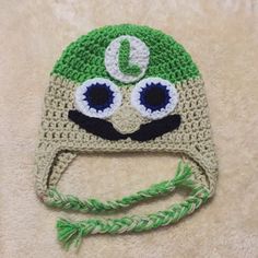 a crocheted green and white hat with eyes