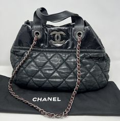 This CHANEL tote is a stunning addition to any outfit. The iridescent leather and quilted texture add a touch of luxury, while the large size and chain strap make it practical for everyday use. The bag features a magnetic closure and silver hardware, with a red lining and accents to add a pop of color. It measures 18" in length, 13" in height, and 8" in depth with a 5" and 16" strap drop. Made in Italy, this tote is perfect for women who want to elevate their style. Whether you're running errand Luxury Quilted Double Handle Bag, Designer Quilted Top Handle Bag, Designer Quilted Bag With Double Handle, Designer Quilted Shoulder Bag For Travel, Designer Quilted Tote Shoulder Bag, Designer Quilted Crossbody Bag, Designer Quilted Bag For Everyday, Designer Quilted Satchel Shoulder Bag, Quilted Double Handle Shoulder Bag