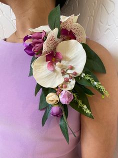 a woman wearing a purple dress holding a bouquet of flowers