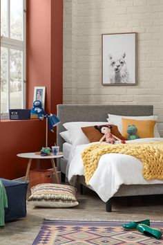 a bedroom with red walls and white bedding has a teddy bear on the bed