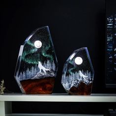 two glass vases sitting on top of a table with a night sky and stars in the background