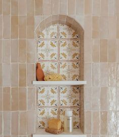 a shelf with some items on it in a room filled with tile walls and flooring