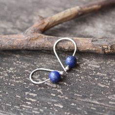 Lapis lazuli sterling silver earringsDainty 3/4" sterling silver budded open hoops with 6mm dark blue pyrite flecked lapis lazuli stones.Made to order ~ minor variations in stone character♥ Open hoops are applied to your ears by grasping the open ends in each hand and gently pulling one end up and one end down, then simply slide them in your ear. DO NOT pry them open then pinch them closed, they will lose shape and not close properly.HOW TO properly put on any kind of hoop earring. Copy and past Unique Handmade Sterling Silver Cartilage Earrings, Minimalist Blue Wire Wrapped Earrings, Handmade Dainty Drop Cartilage Earrings, Dainty Handmade Drop Cartilage Earrings, Nickel-free Blue Cartilage Earrings As Gift, Handmade Lapis Lazuli Jewelry For Everyday, Handmade Minimalist Drop Cartilage Earrings, Minimalist Handmade Dangle Cartilage Earrings, Handmade Minimalist Lapis Lazuli Jewelry