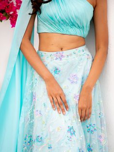 A two-piece Blue floral multi sequins lehenga with light blue drape blouse from the Shrena Hirawat collection. This beautiful cotton satin blue drape blouse is paired with a semi satin georgette blue floral multi sequins lehenga. The multi sequin floral embroidery with cancan, and butter crepe lining enhance this lehenga set. This outfit is completed with a blue dupatta attached to the drape blouse. Blue Sharara For Spring, Designer Blue Sharara For Spring, Spring Wedding Blue Sharara, Spring Reception Sharara With Traditional Drape, Spring Festive Silk Pre-draped Saree, Blue Saree Sets For Spring, Spring Blue Saree Set, Spring Choli With Dupatta For Reception, Spring Reception Choli With Dupatta