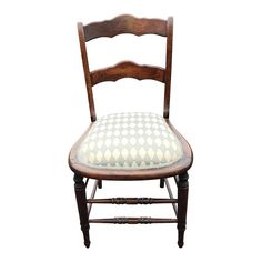 an old wooden chair with a checkered seat cushion on it's backrest