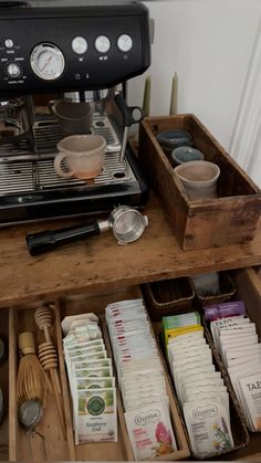 an espresso machine sitting on top of a wooden table next to other items