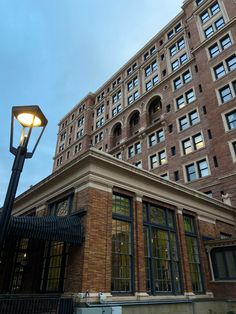 an old brick building with many windows and a street light