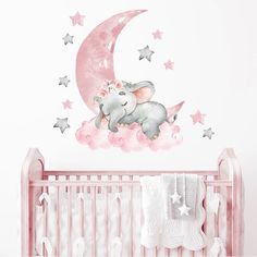 an elephant sitting on top of a pink cloud next to a baby's crib