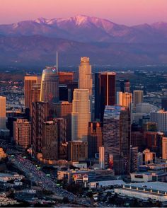 an aerial view of a city with mountains in the background