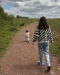 two children are walking down a dirt road