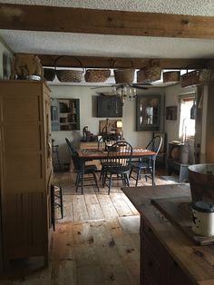 an open kitchen and dining room with wood flooring in the center, along with lots of wooden furniture