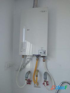 a tankless water heater mounted to the side of a wall in a bathroom