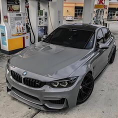 a silver car parked in front of a gas station