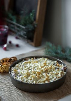 a pan filled with food sitting on top of a table next to some crackers