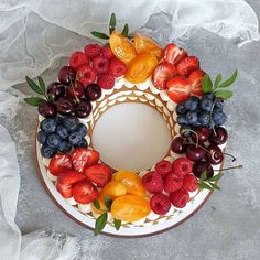 a cake decorated with fresh fruit and leaves