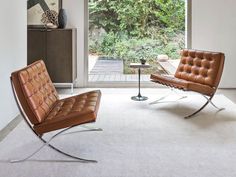 two leather chairs in front of a sliding glass door