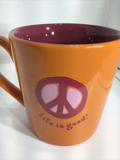 a coffee cup with the word life is good written on it and a peace sign