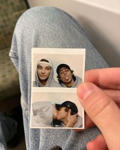 a person holding up two polaroid photos with one man kissing the other