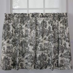 the curtain is hanging in front of a window with trees and bushes printed on it