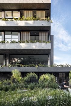 an apartment building with plants growing on the balconies