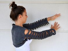 a woman leaning against a wall with her arms stretched out