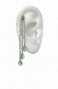 a pair of earrings with chains hanging from it's ear and beads attached to them