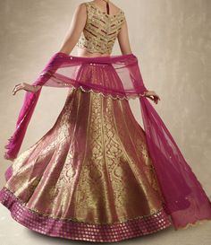 This exquisite Purple Pink Embroidered Banarasi Lehenga Set is crafted from luxurious Banarasi fabric, featuring rich kalidar purple pink lehenga adorned with a striking mirror-embellished belt and border that add a glimmer of sophistication to its traditional weave. Teamed with a classic mirror work blouse, intricately embellished with dori, mirrors, beads, and sequins, exuding an opulent charm. A lightweight tulle dupatta completes the look, delicately sprinkled with mirror buttis and finished Benarasi Lehengas, Mirror Belt, Brocade Lehenga, Net Blouse, Net Skirt, Mirror Work Blouse, Scallop Border, Organza Lehenga, Net Blouses