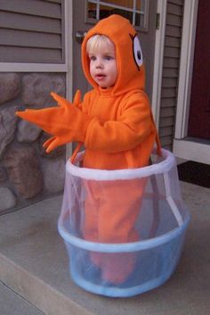 a little boy dressed in an orange costume