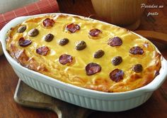 a casserole dish with cheese and pepperoni in it on a wooden table